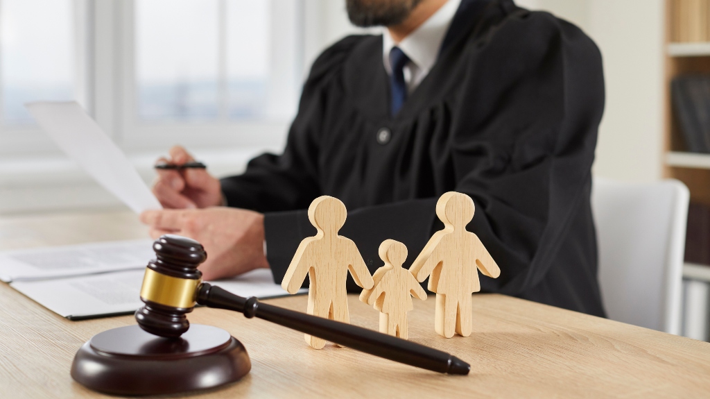 Gavel and little wooden figures of husband, wife and child