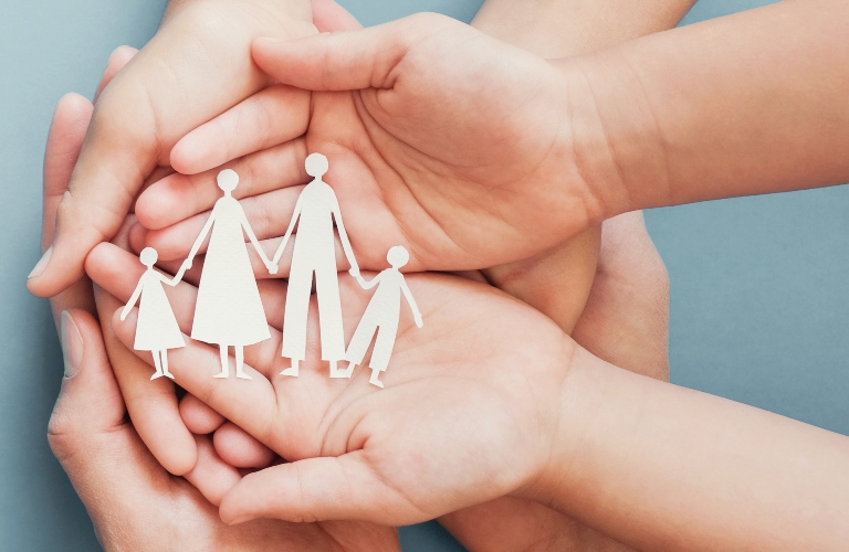 Adults and children holding paper family cutout