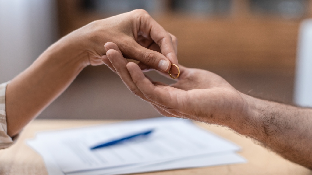 Hand of female gives ring to her ex husband
