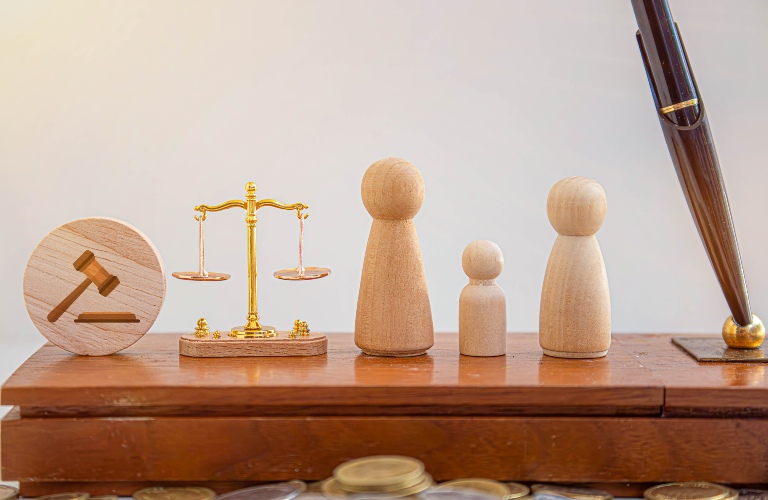 judge and scales of justice with wooden family figures