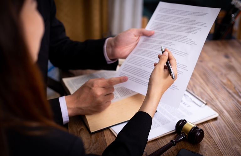lawyer sorts through divorce papers with a client