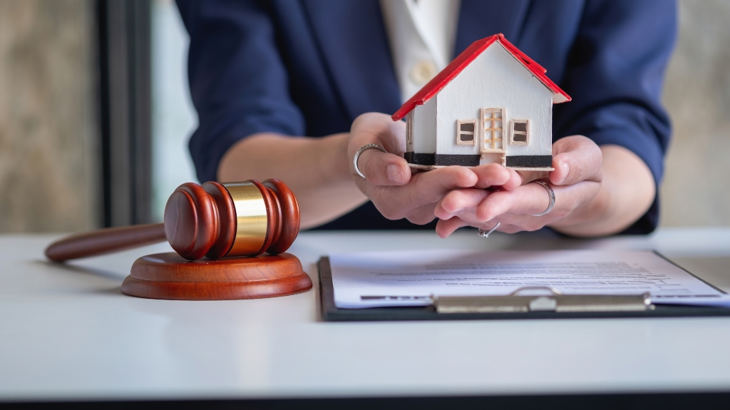 lawyer holding a model of a wooden house