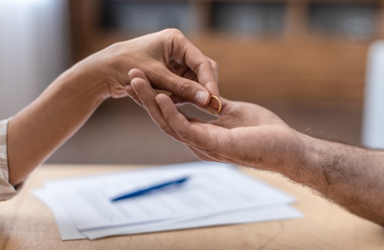 Hand of adult female gives ring to her ex husband