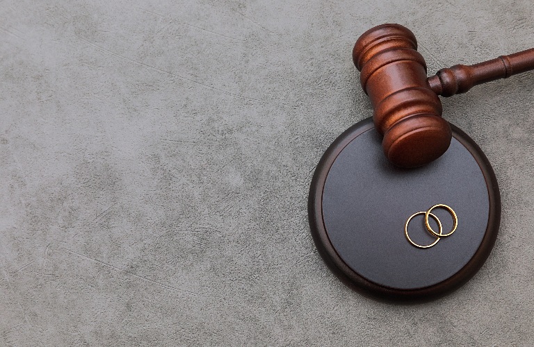 Judge gavel wedding rings on concrete stone grey background