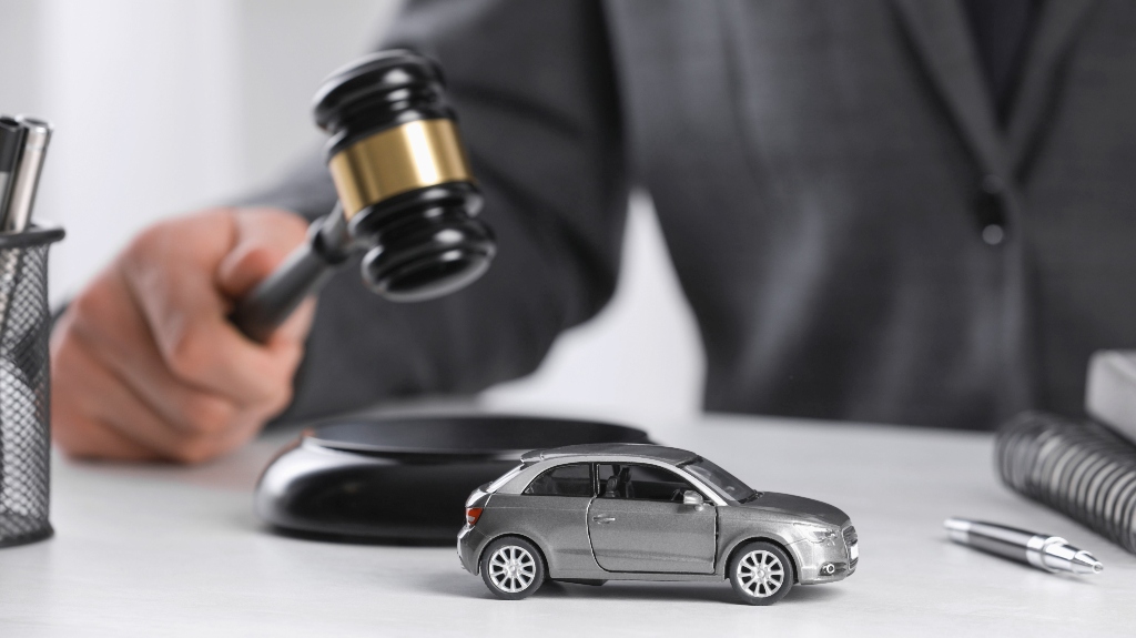 lawyer with judge's gavel and grey toy car