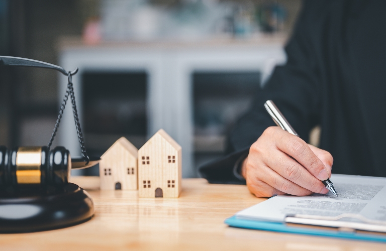 Lawyer with documents, wooden house and judge's gavel