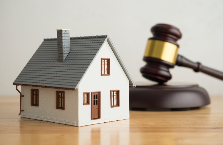 House model, judge's gavel on wooden table