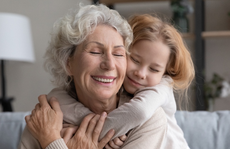 little girl hugs her grandmother