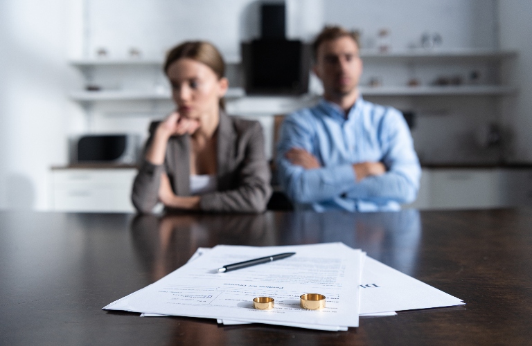 divorced couple looking at rings and paperwork