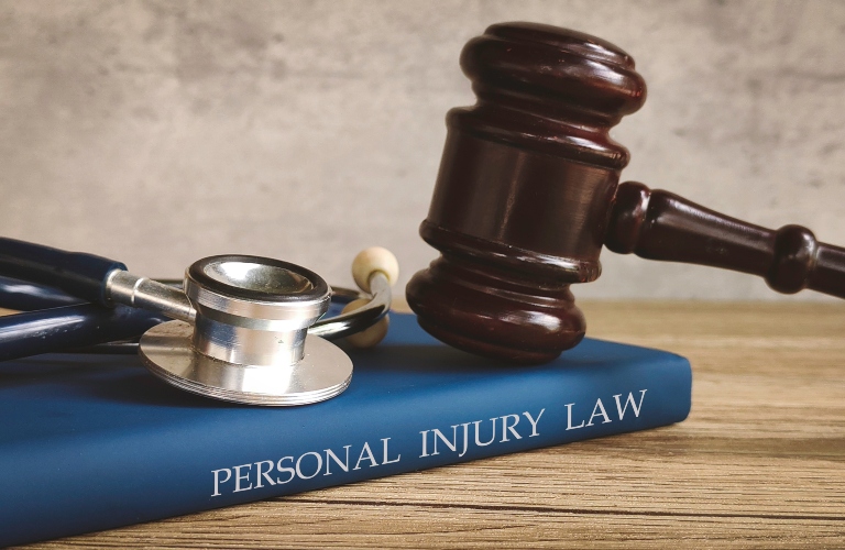 Gavel and stethoscope on a book titled  PERSONAL INJURY LAW