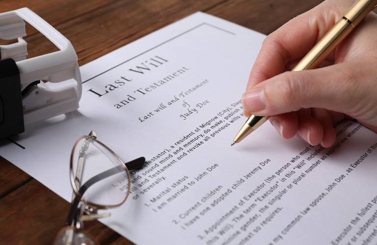 Woman signing Last Will and Testament at wooden table
